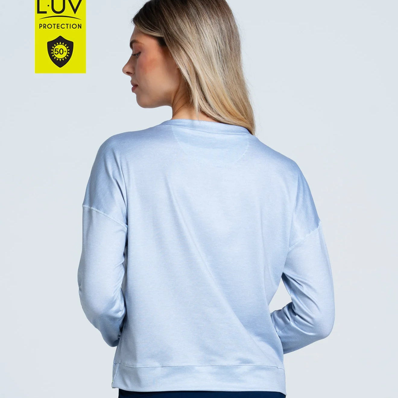 Back of model wearing a long sleeve shimmery light grey Lucky in Love LUV sun protected top.