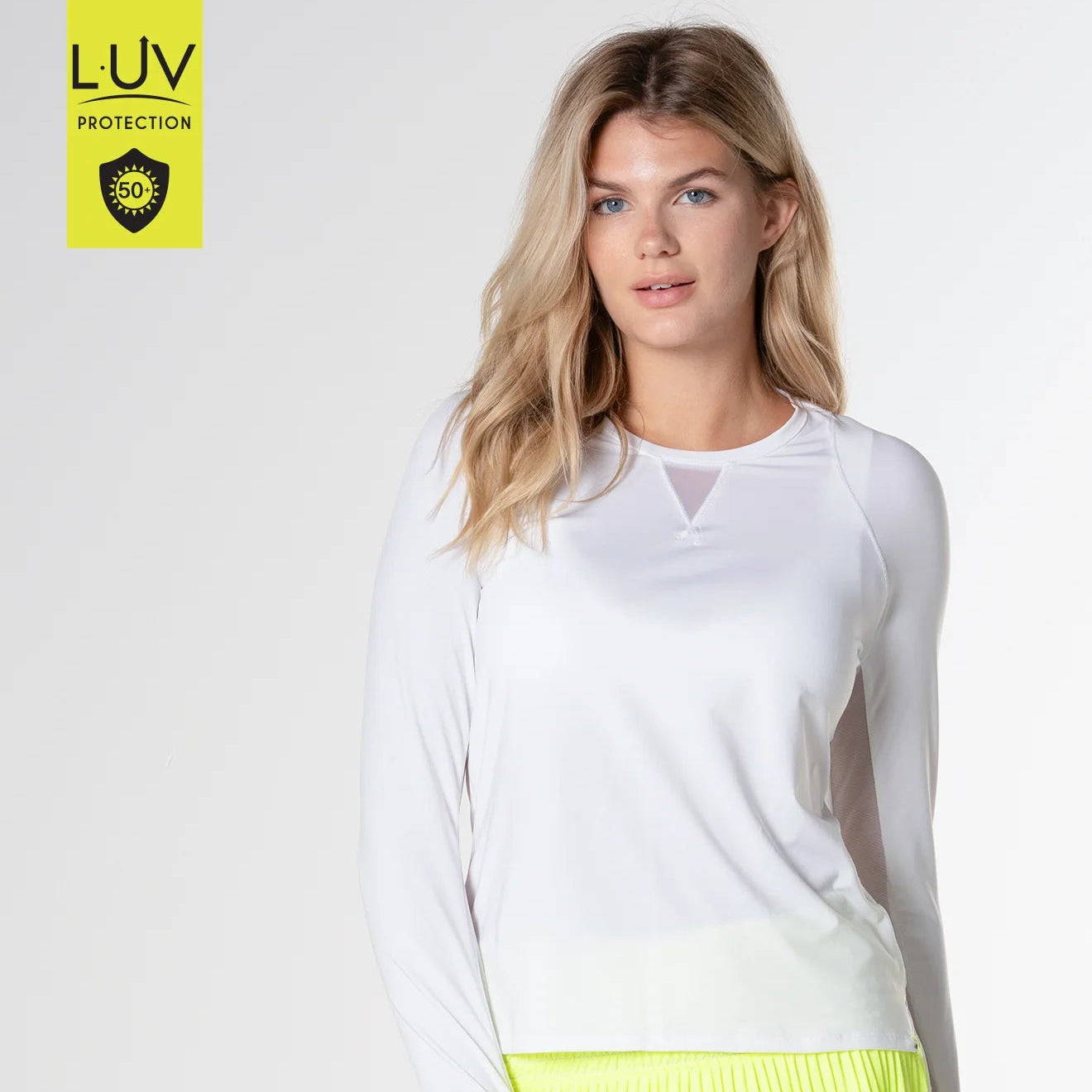 A woman wearing a long sleeve white shirt and a neon yellow skirt.