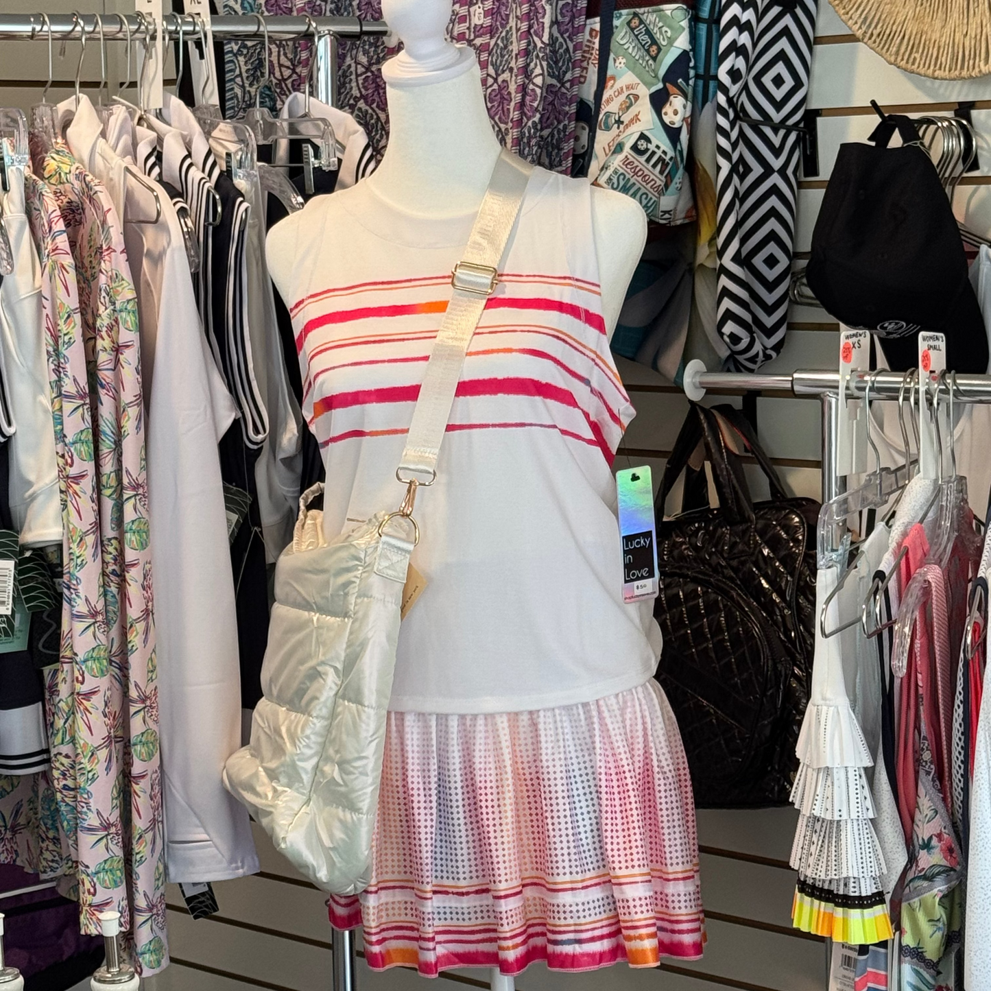 Manican wearing Lucky in Love smocked waist band skirt. Featuring a sporty border stripe for a pop of color in hot pink, orange, yellow and light blue and matching tank, with a puff shoulder cross bag