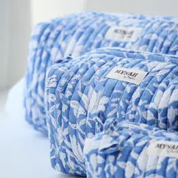 Blue and white floral print travel makeup organizers with the brand name 'MYNAI' visible on the fabric.