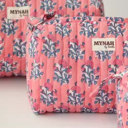 A pink travel makeup organizer with a melon sorbet print, featuring a zipper and a brand tag showing 'MYNAH'.