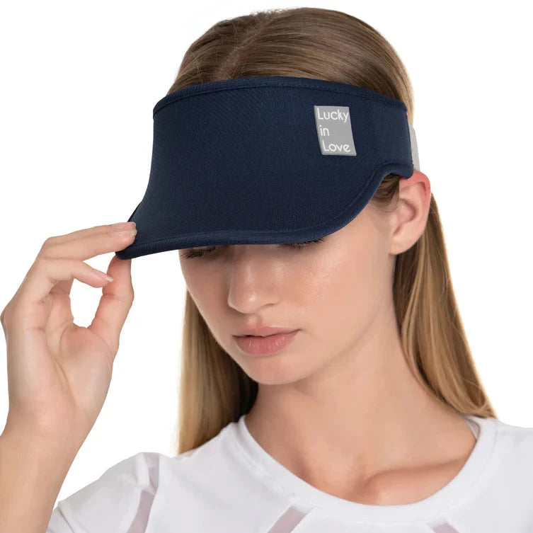 A navy blue sport visor with a logo that reads 'Lucky in Love' on the front, worn by a female model.