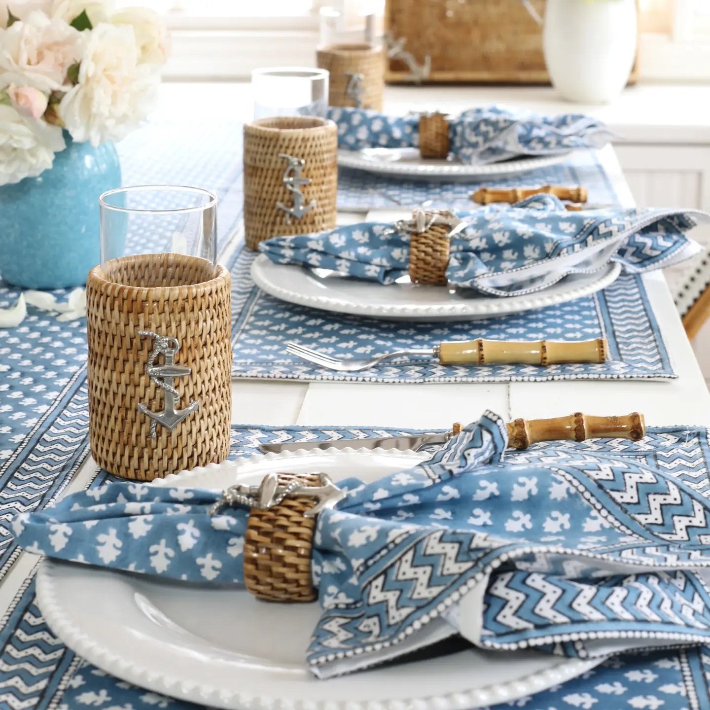 A table setting picture of a table set with Pacific Rose blue and white napkins