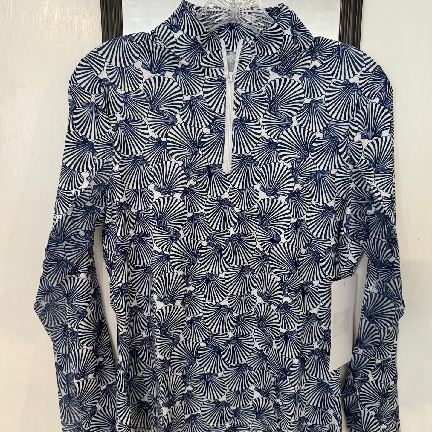 Half zip high performance, sun protective, and sporty style top in navy and white with sea shell design.
