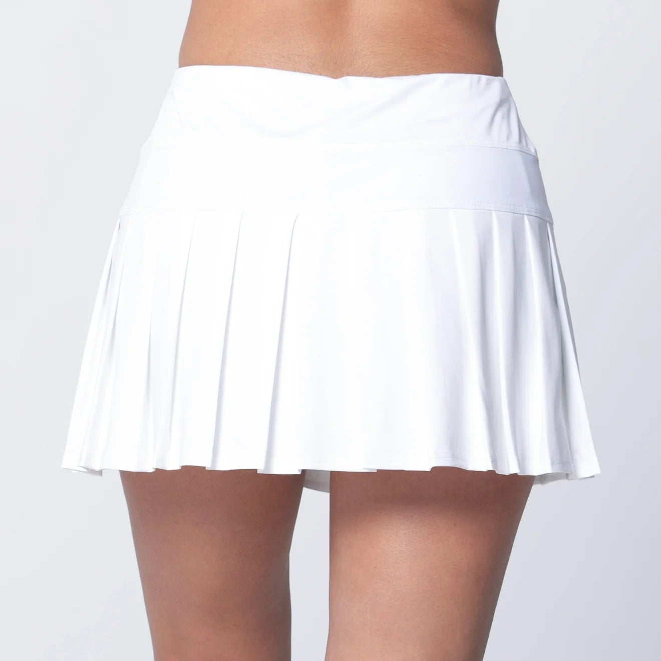Back view of pleated white tennis or pickleball skirt brings next-level movement with a wide, flattering waistband and lightweight performance fabric that flows with every step.