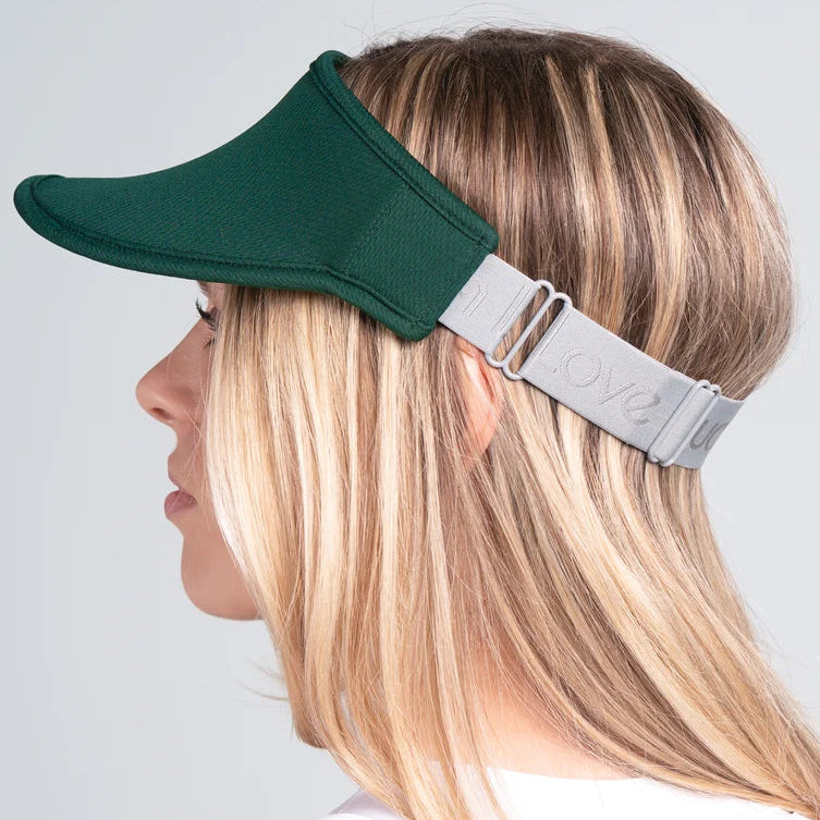 Side view of woman wearing our forest green performance visor. French terry fabric on the inside headband has moisture wicking.
