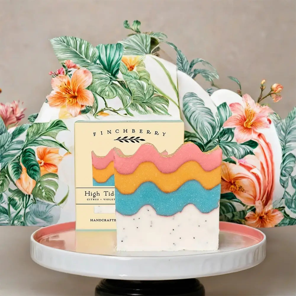 Colorful cake with floral decorations and a box labeled 'Finchberry' on a neutral background