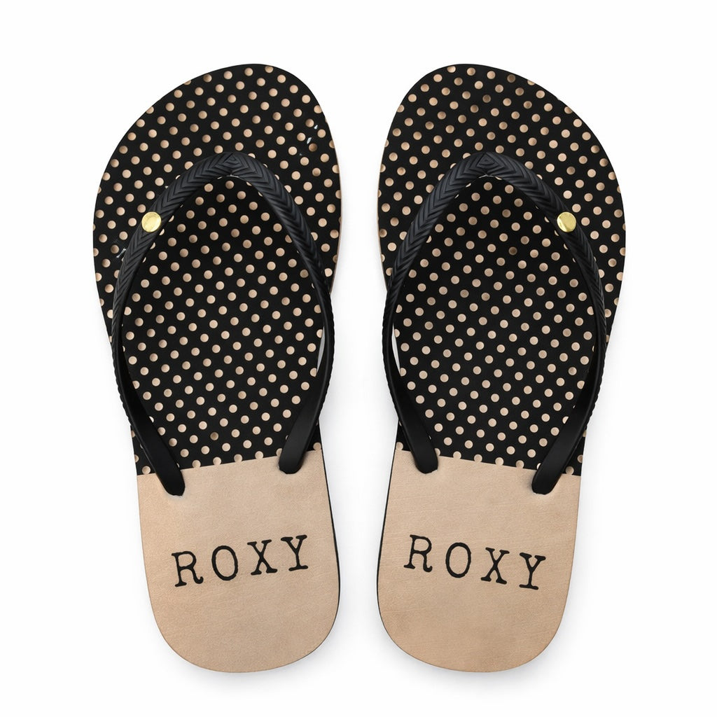 Pair of black and beige polka dot flip-flops with 'ROXY' branding on a white background