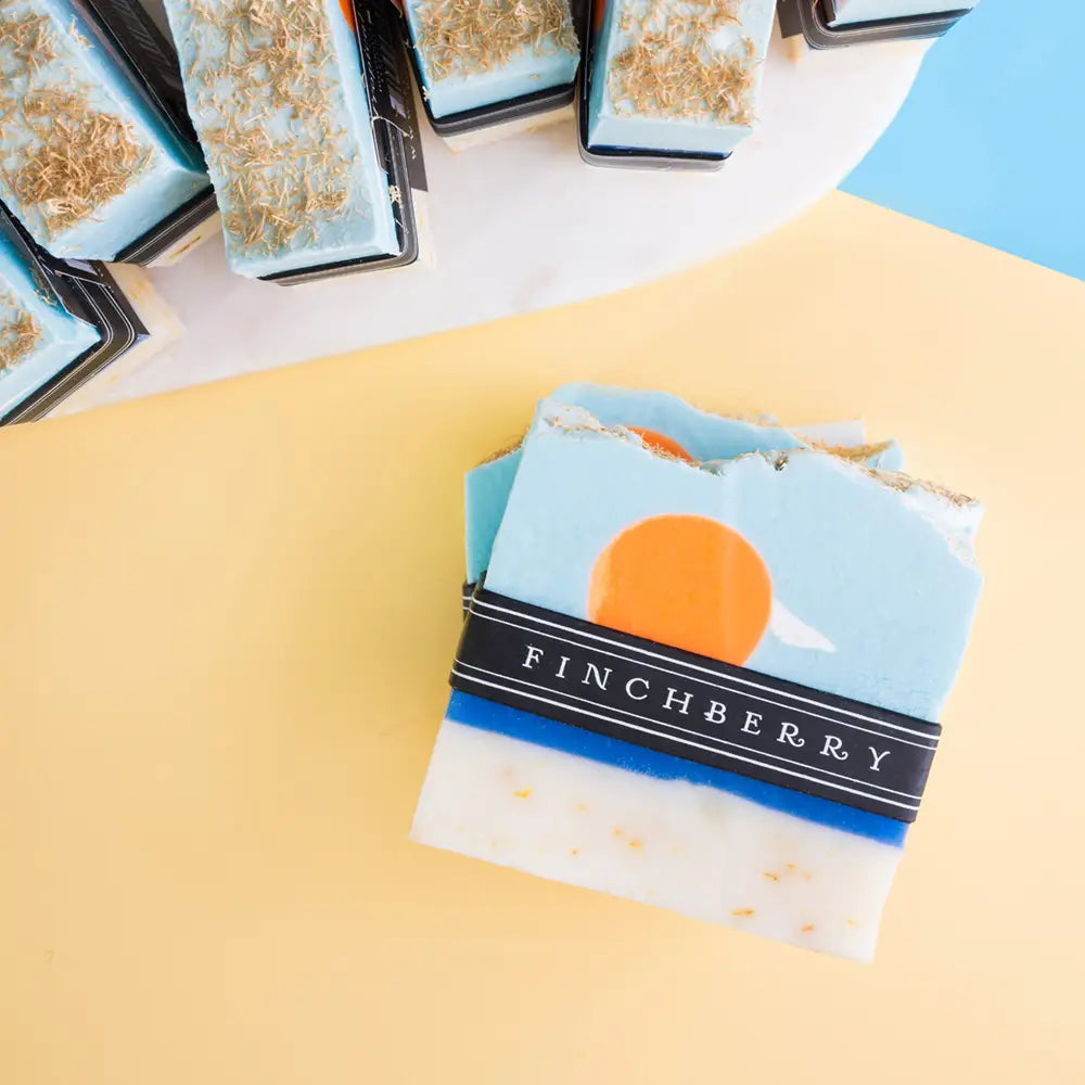 Packaged soap bars with 'Finchberry' branding on a yellow surface