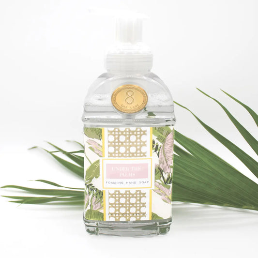 Foaming hand soap Under the Palms collection in pink and green tropical design of banana leaves and palms; the fragrance blends zesty citrus with cooling mint, and warm amber