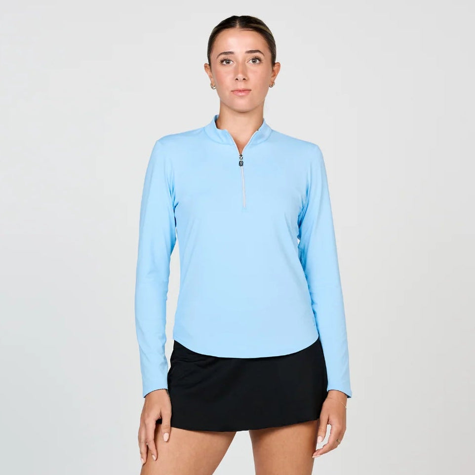 Woman wearing Sofibella long sleeve tennis top with zip front closure and mini Mandarin collar, and flattering curved hem line, made of soft UPF 50+ fabric, with mesh under sleeve inserts for ventilation in color Cloud.