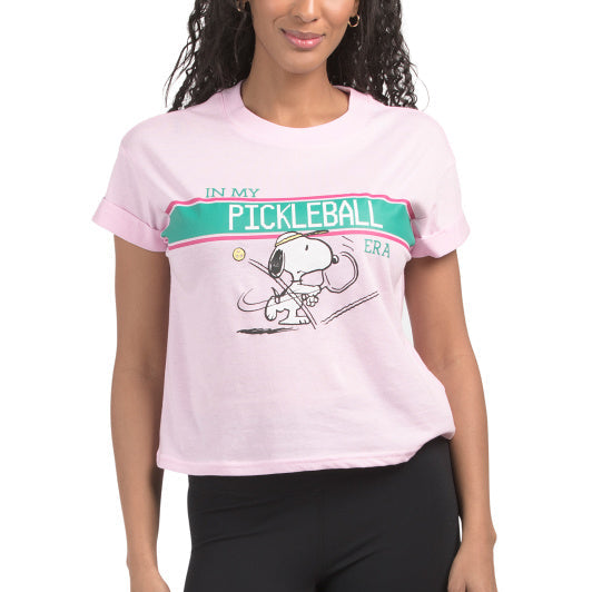 Woman wearing a pink t-shirt with a Snoopy pickleball-themed design