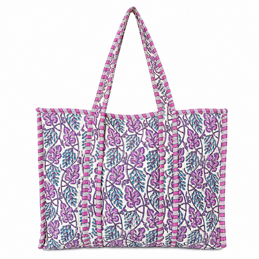 Tote bag with a white base and a vibrant purple, pink, and teal floral block print, featuring thick striped handles and a striped border along the edges.