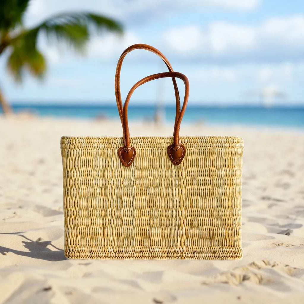woven market bag with ong leather handles on a beach